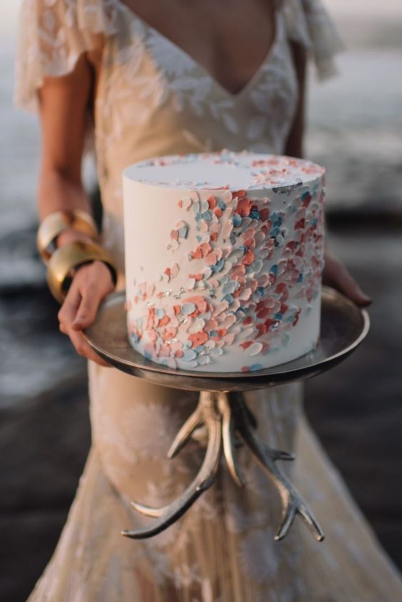 In pieno e dicembre, e con il Natale che avanza a passi sempre più svelti, oggi vogliamo parlarvi delle wedding cake 2018 di tendenza perché i giorni freddi trascorsi sul divano sono i migliori per decidere piano i dettagli del proprio matrimonio, torta nuziale compresa!   Dopo la sposa, la wedding cake è la regina indiscussa del wedding party. Se anni fa era una parte del tutto, e si presentava più o meno semplice, oggi si riveste un ruolo ben più importante, si carica di significati scenografici e può essere considerata l’emblema del taglio stilistico dato al proprio matrimonio.  Chi ci conosce lo sa, ci piace sperimentare e crescere ogni anno, proporre idee nuove, alla moda e ovviamente sempre eleganti, e la nostra ricerca di queste ultime settimane ci conduce oggi a presentarvi 5 idee wedding cake 2018 che sono di tendenza, belle da vedere e buone da mangiare.  1. Wedding cake 2018: DRESS WEDDING CAKE È la torta nuziale che ripropone l’abito della sposa, un suo dettagli o lo stesso stile che l’hanno ispirato. Il risultato è meraviglioso e verrete ricordati per due sposi che hanno avuto cura del particolare massima. Niente da lasciare al caso, insomma.  2. Wedding cake 2018: DRIP WEDDING CAKE Le drip cake, o torte che gocciolano, hanno solitamente piano dal diametro ampio e una copertura di glassa con effetto gocciolante sui lati. Possono poi essere decorate con frutta, praline o con quello che si preferisce, purché in linea con il mood dell’insieme. Sono wedding cake adatte ad arredare l’ambiente che ospita il taglio della torta nuziale.  3. Wedding cake 2018: JEWEL WEDDING CAKE Stiamo parlando delle torte gioiello, vale a dire delle torte nuziali adeguate ai più chic che strizzano l’occhio alla tradizione. È preferibile partire dal fondo bianco per far risaltare di più l’effetto luminoso del gioiello sulla glassa. Consigliata in ambienti dai grandi lampadari di cristallo o nei saloni di specchi.  4. Wedding cake 2018: MINI WEDDING CAKE Una piramide di tantissime mini wedding cake, diverse o tutte uguali a seconda dei gusti, per appagare qualsiasi palato e permettere a tutti gli invitati di provare l’ebbrezza di tagliare la wedding! Scenografica e minimal insieme, sicuramente romantica.  5. Wedding cake 2018: CHALKBOARD WEDDING CAKE Detta anche “torta di nozze a lavagna” è sicuramente la più innovativa tra le nuove proposte per i matrimoni 2018. Può ospitare un messaggio direttamente sulla glassa, un pensiero, il mood delle nozze o il profondo sentire della coppia. Perfetta per le dediche a sorpresa dello sposo alla sposa, si adatta bene a ricevimenti di nozze dal piglio contemporaneo e dagli allestimenti underground.   Infine, tra le wedding cake 2018, non può mancare un richiamo alla NAKED CAKE, sul mercato delle novità cake sposi da qualche anno ma sempre in gran voga. Questa torta non è ricoperta al suo esterno ma lascia intravedere gli strati interni. Ne avevano parlato qui: MaggiorDomus naked cake.  E voi? Qual è la vostra wedding cake preferita tra le novità che abbiamo in cantiere per i ricevimenti di matrimonio 2018?